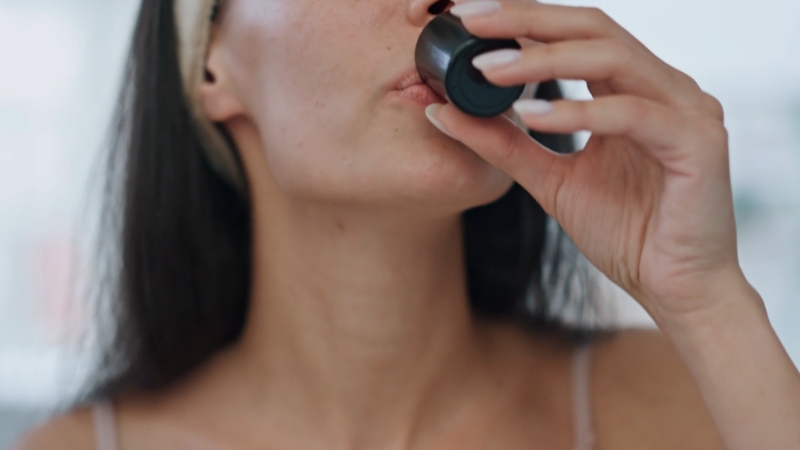 A woman gently rinsing her mouth as part of care after a tooth extraction