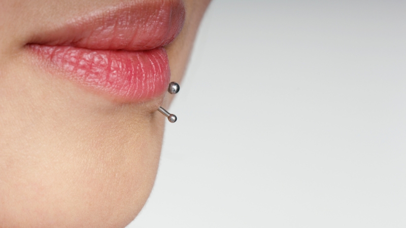 Lip piercing with metal jewelry placed through the lower lip