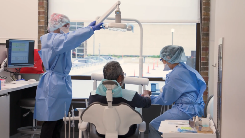 Three Dental Workers Help a Patient in A Dental Chair at The University of Michigan